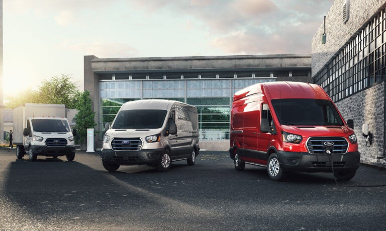 Three 2023 Ford E-Transits parked in lot with one charging